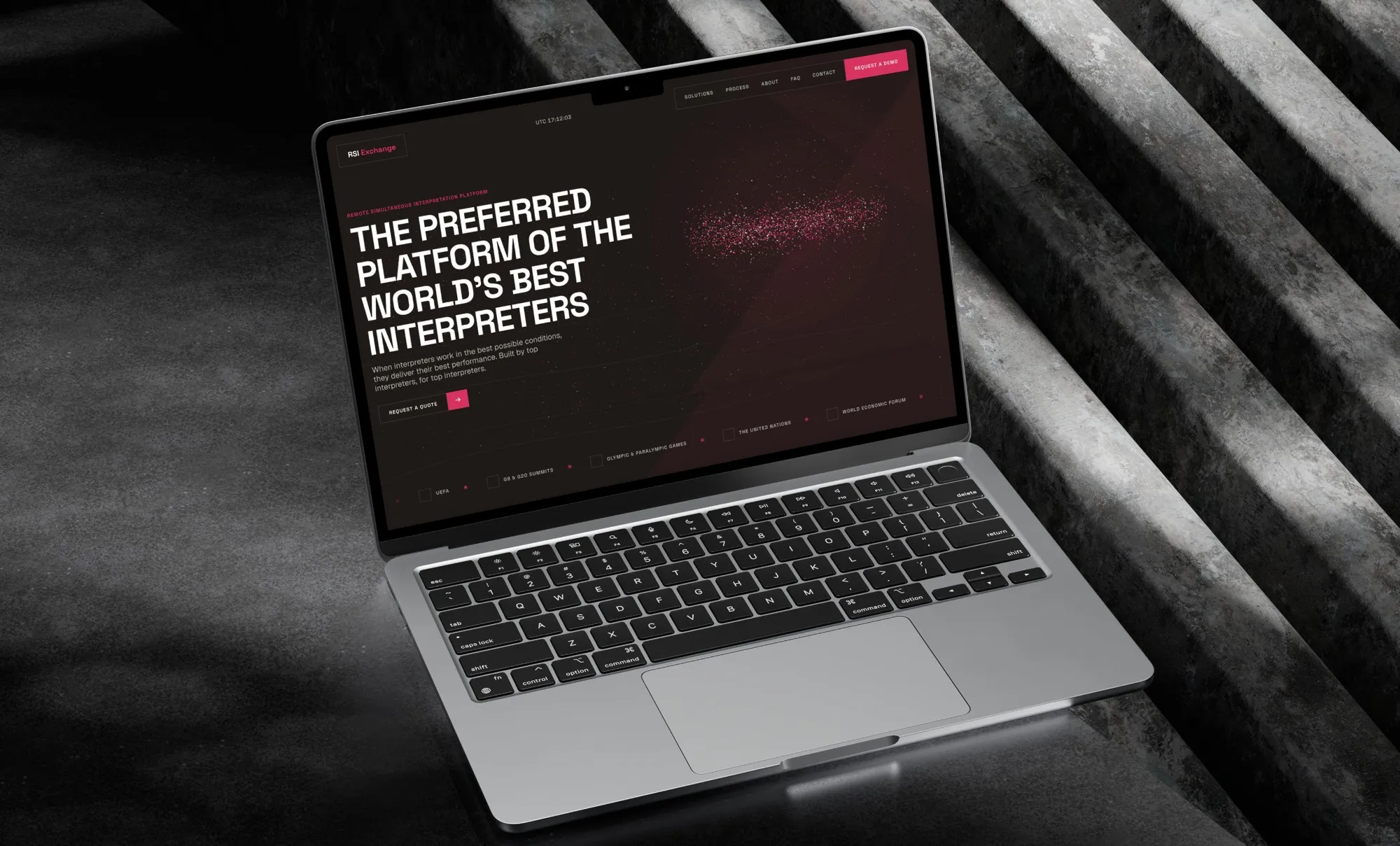 Laptop on dark concrete steps showing the RSI Exchange homepage: “The preferred platform of the world’s best interpreters”