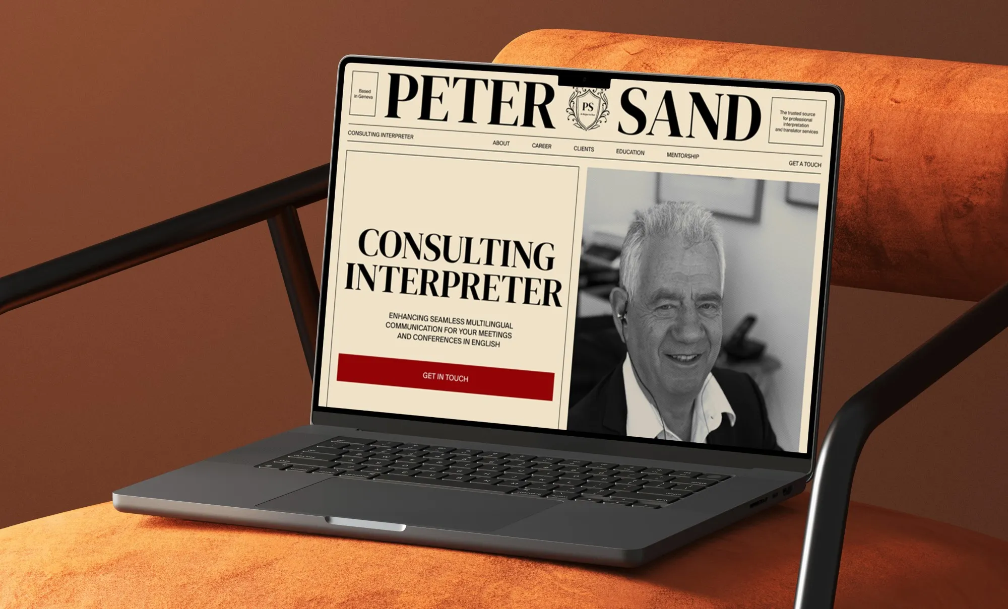Laptop on an orange armchair showing the Peter Sand homepage: the newspaper-style masthead and “Consulting interpreter” beside his portrait